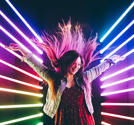 Person With Arms Up Having Fun in Neon Lit Photo Booth That is The Amazing 360